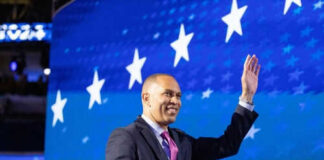 Man in suit waving against starry blue background