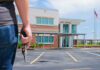Person holding a handgun outside a high school building