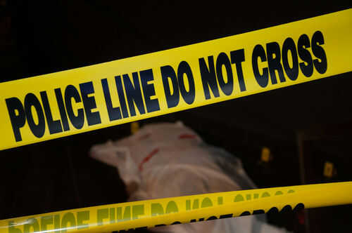 murder-victim527676868 Police tape and covered figure at crime scene