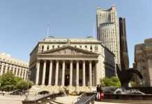 Neoclassical courthouse with tall columns and nearby modern tower