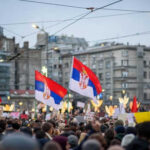 Swiss Population Cap Plan Sparks EU Showdown Crowd holding Serbian flags during protest in city