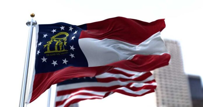 Georgia state flag waving in the wind with an American flag in the background