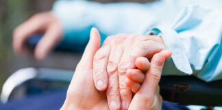 Two hands clasped together, symbolizing care and support