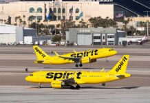 Two Spirit Airlines planes on a runway at an airport