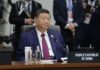 Beijing’s Tawain Threat Puts Trump in Tight Spot A leader seated at a conference table during an international summit