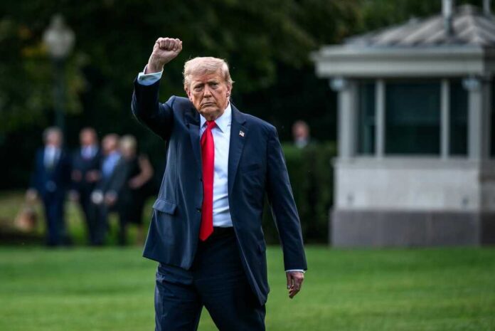 A political figure raising a fist while walking outdoors