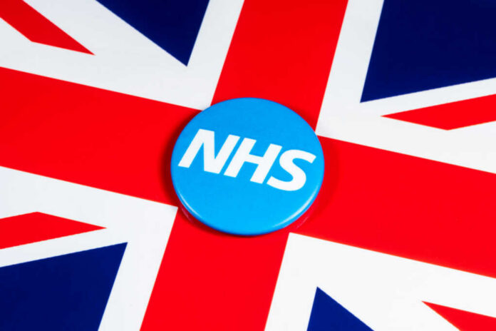 uk-flag-nhs1079019797jpg Blue NHS badge on the Union Jack flag
