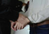 Person in handcuffs wearing jeans and white shirt