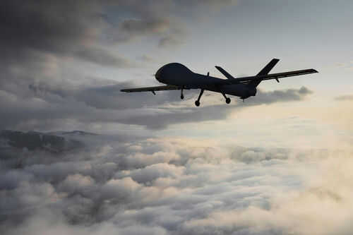 Drone flying above clouds during sunset.