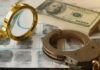 Magnifying glass handcuffs fingerprints money on table