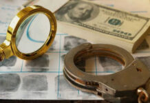 Magnifying glass handcuffs fingerprints money on table