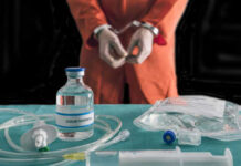 Supreme Court Halts Grisly Alabama Experiment Handcuffed person in orange jumpsuit behind medical equipment