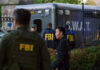 88 Inmates Overrun Jail — FBI Swarms FBI and SWAT team gathered near vehicle.