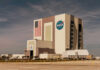 NASA’s Risky Docking Gamble NASAs Vehicle Assembly Building with Artemis sign.