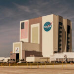 NASA’s Risky Docking Gamble NASAs Vehicle Assembly Building with Artemis sign.
