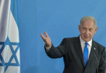 Lebanon Inferno Threat Rattles Washington Man speaking next to Israeli flag.
