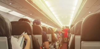 airplane cabin with passengers seated in rows