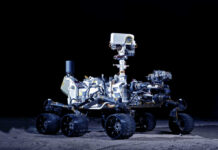 Robot Kill Zone Upends War Mars rover with six wheels and camera mast on dark background