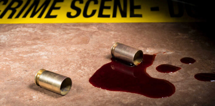 Beige,Tile,Covered,In,Blood,With,Two,Pistol,Casings,And Bullet casings and blood on a surface near a crime scene tape