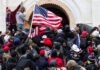 Moral Meltdown Grips America Crowd with American flag pushes into building entrance