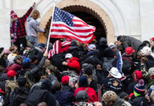 Moral Meltdown Grips America Crowd with American flag pushes into building entrance