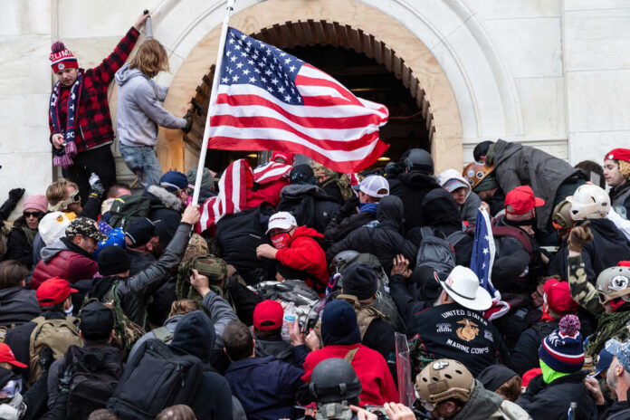 Crowd with American flag pushes into building entrance