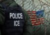 Antifa Terror Plot Nailed By Feds Police officer in tactical gear standing near a barbed wire fence with an American flag in the background