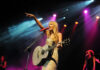 Singer with acoustic guitar performing on stage