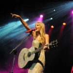 Singer with acoustic guitar performing on stage