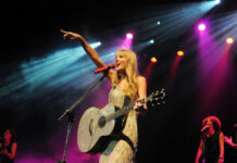 Singer with acoustic guitar performing on stage