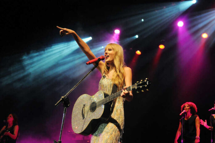 Singer with acoustic guitar performing on stage
