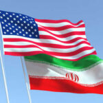 Oil Lifeline Hangs On Trump Gamble American and Iranian flags waving in the sky.