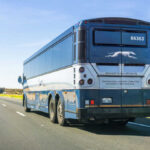 Rear view of a blue intercity coach bus on a highway