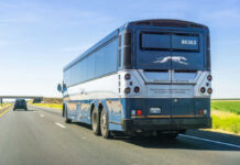Rear view of a blue intercity coach bus on a highway