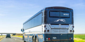Rear view of a blue intercity coach bus on a highway