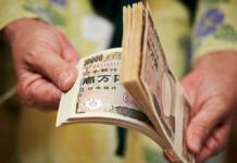 Japan Bankrolls AI Memory Powerhouse Hands counting a thick stack of Japanese yen banknotes