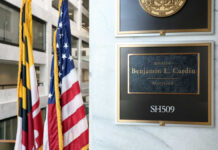 Flag YANKED At Boston City Hall? Office plaque beside U.S. and state flags in a government building