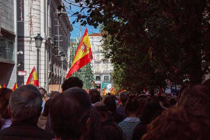 shutterstock_2387482013 Crowd with Spanish flags in a city street