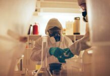 Why America Sends Ebola To Germany Scientists in protective gear conducting an experiment in a laboratory