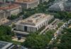 Legal Bombshell Freezes Trump’s Mega-Arch Aerial view of a large modern museum building with surrounding trees and buses