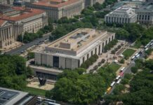 Legal Bombshell Freezes Trump’s Mega-Arch Aerial view of a large modern museum building with surrounding trees and buses