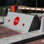 UK City Funfairs Get Armored — Guess Why Rising road blocker with stop sign at a security checkpoint