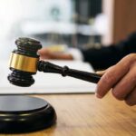 Espionage Plot Exposed Inside DIA Judge's hand holding a gavel over a sound block