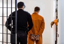 Solitary Shock: Diddy’s Date Suddenly Moves Prisoner in orange jumpsuit handcuffed and escorted by officer
