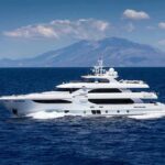 Billionaire Yacht Misses Coast Guard Call Luxury motor yacht cruising on blue sea with mountains in background