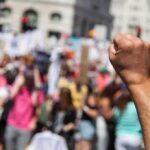 Far-Right Shock: Germany’s Firewall Cracks Raised fist in foreground at a crowded street protest