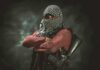 Terror Ties Named — One Name Missing armed person with face covered crossing arms