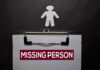 clipboard with missing person notice and paper cutout figure