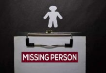 clipboard with missing person notice and paper cutout figure