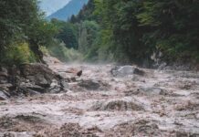 Avalanche Turns Killer Flood Flooded river gorge with fast muddy water and rocks